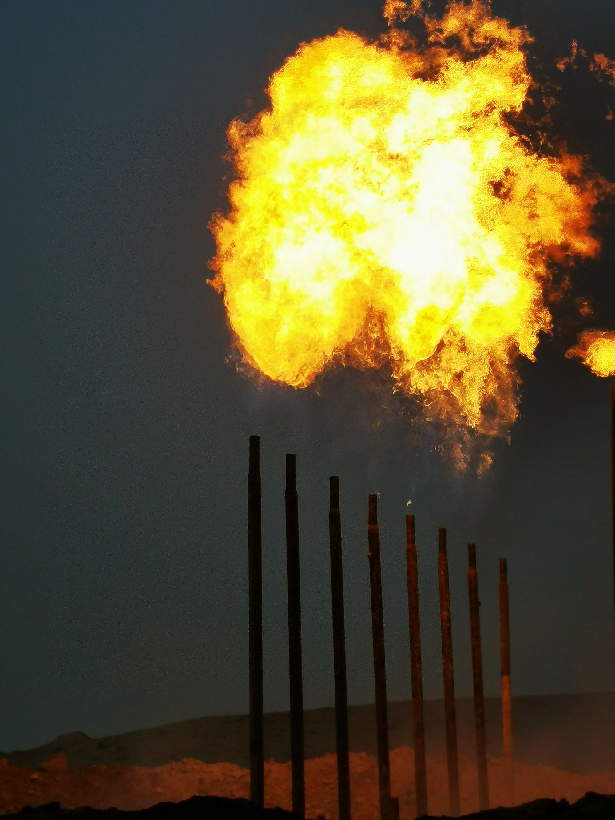 Refinery flare burning against a dark sky