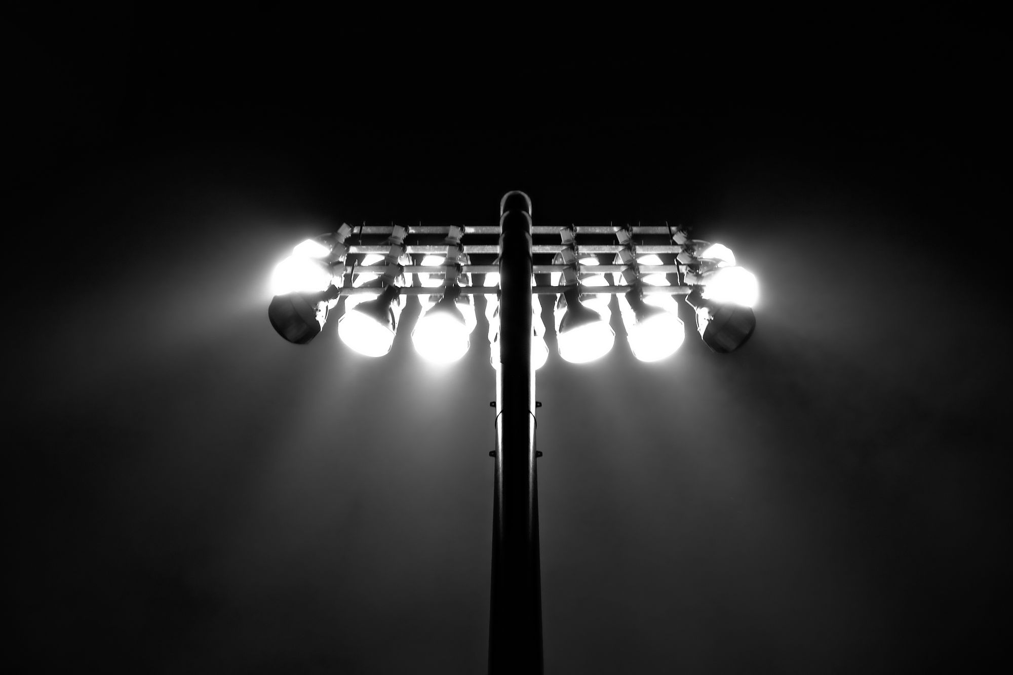 Industrial floodlight mast against a dark sky