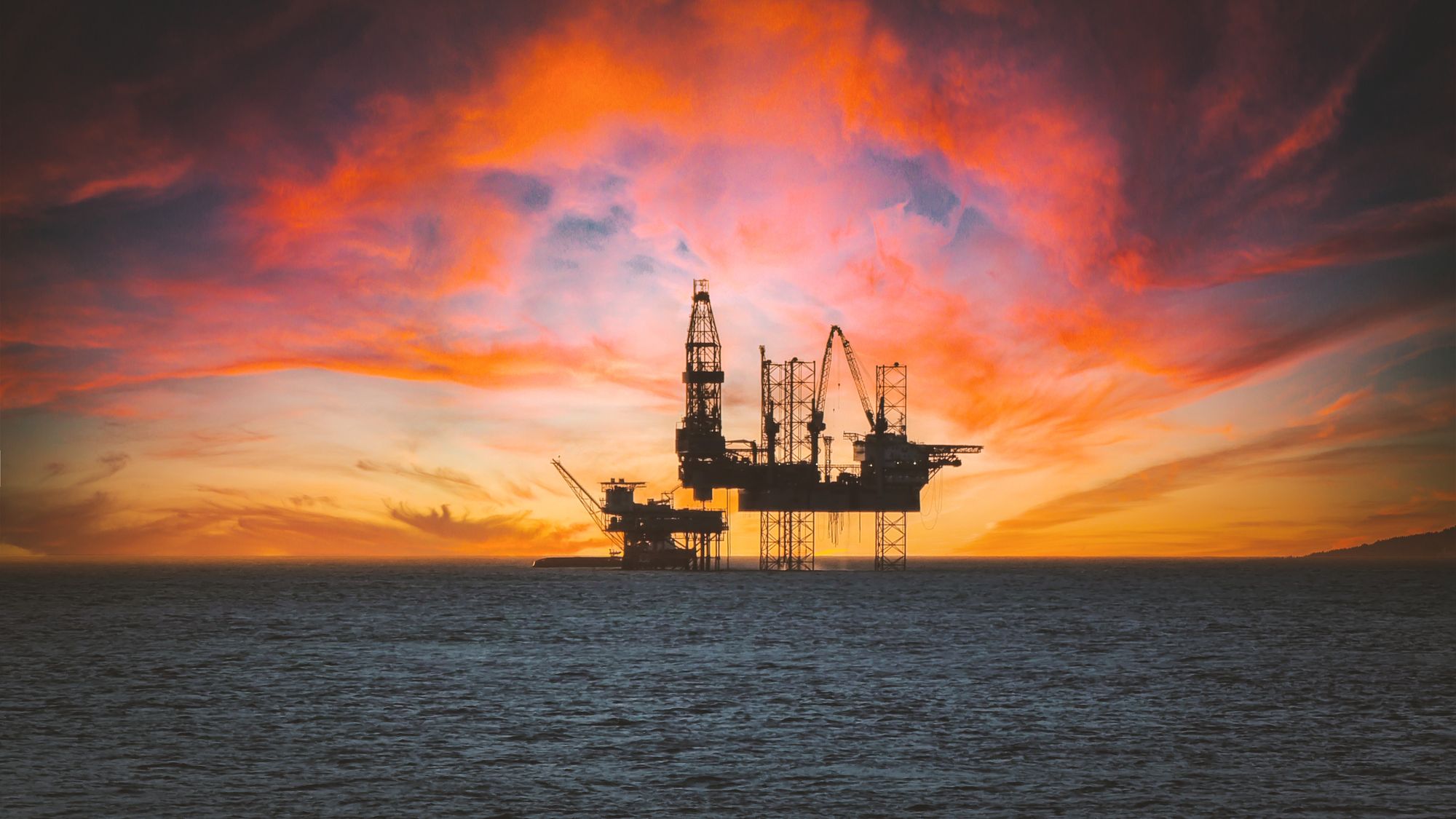 Offshore oil and gas platform at sunset