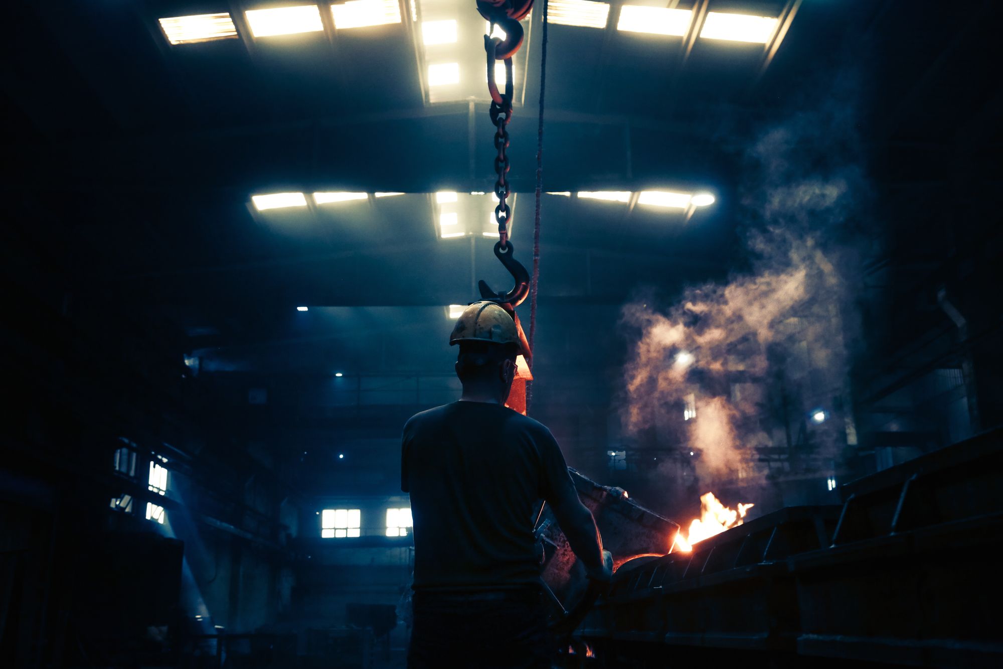 Engineer working with sparks in a dark industrial space