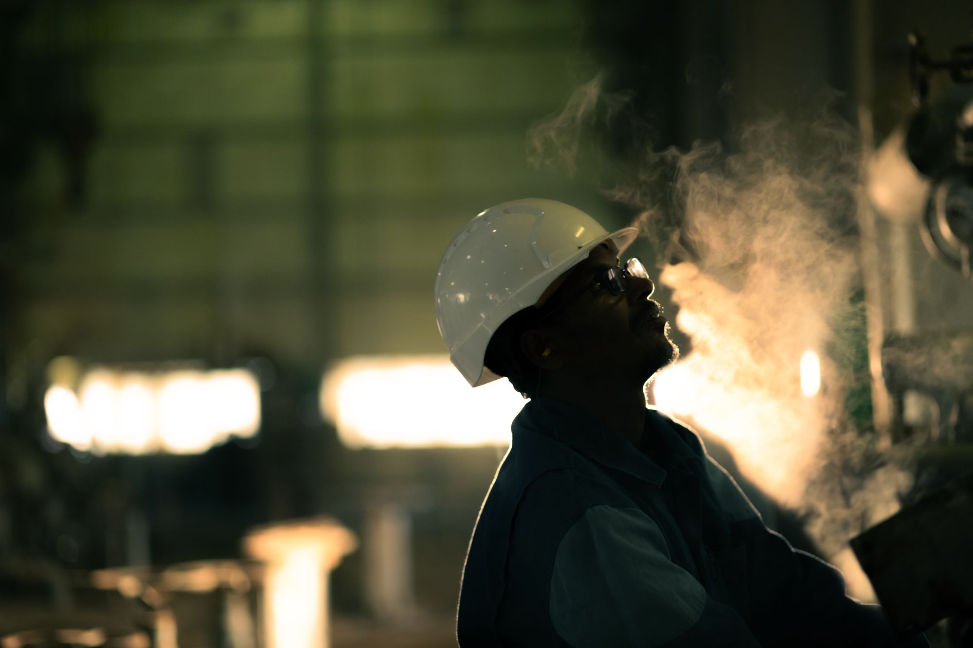 Silhouetted industrial worker in a low-light plant